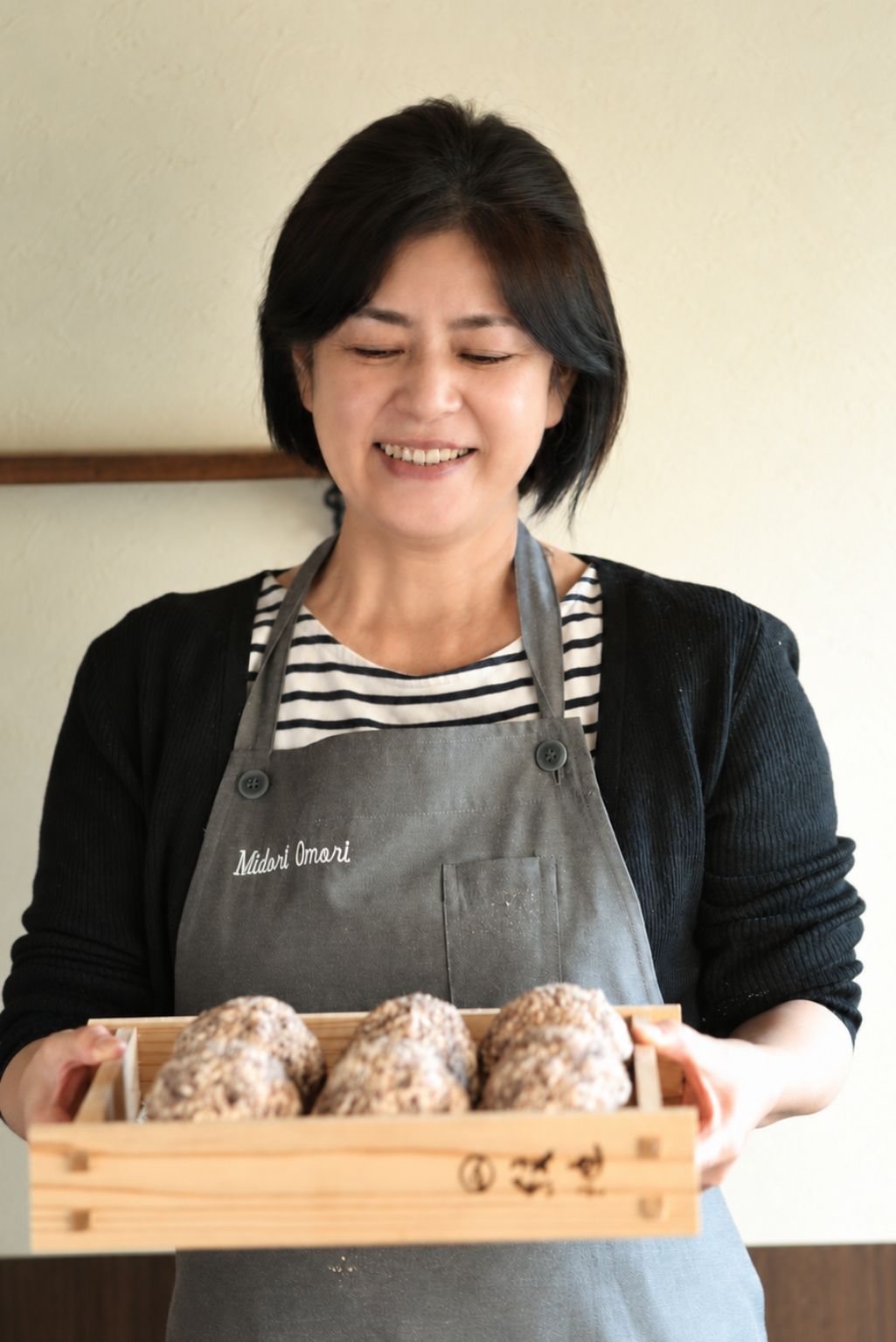 Midori holding a wooden box of miso